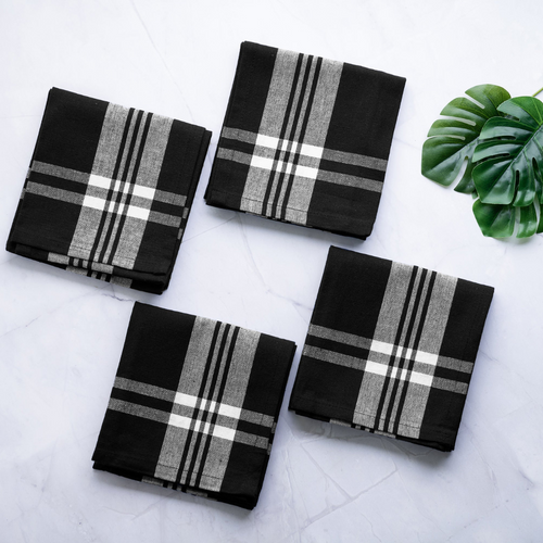 Cozy and modern kitchen setting with high-quality cotton kitchen towels, including one checkered and three striped, neatly folded and presented in a stylish gift box with gourmet cooking utensils and fresh fruits.