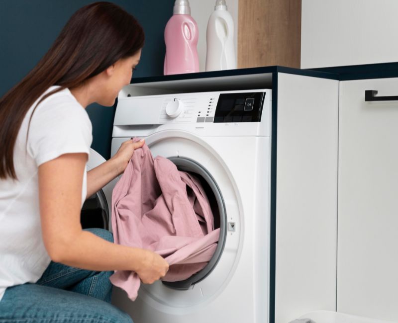 Woman Washing Linen Tablecloth in Washing Machine