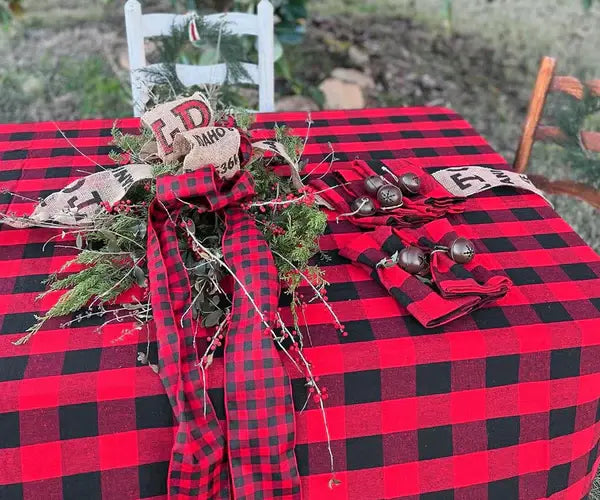 Dining room decorated for Halloween with a black and red checkered tablecloth, pumpkin-shaped candles, and Halloween-themed dishes. 