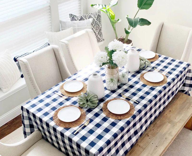  rectangle table covered with a black and white checkered tablecloth, specifically styled for a blog. The setting is designed to project a chic and contemporary look. 