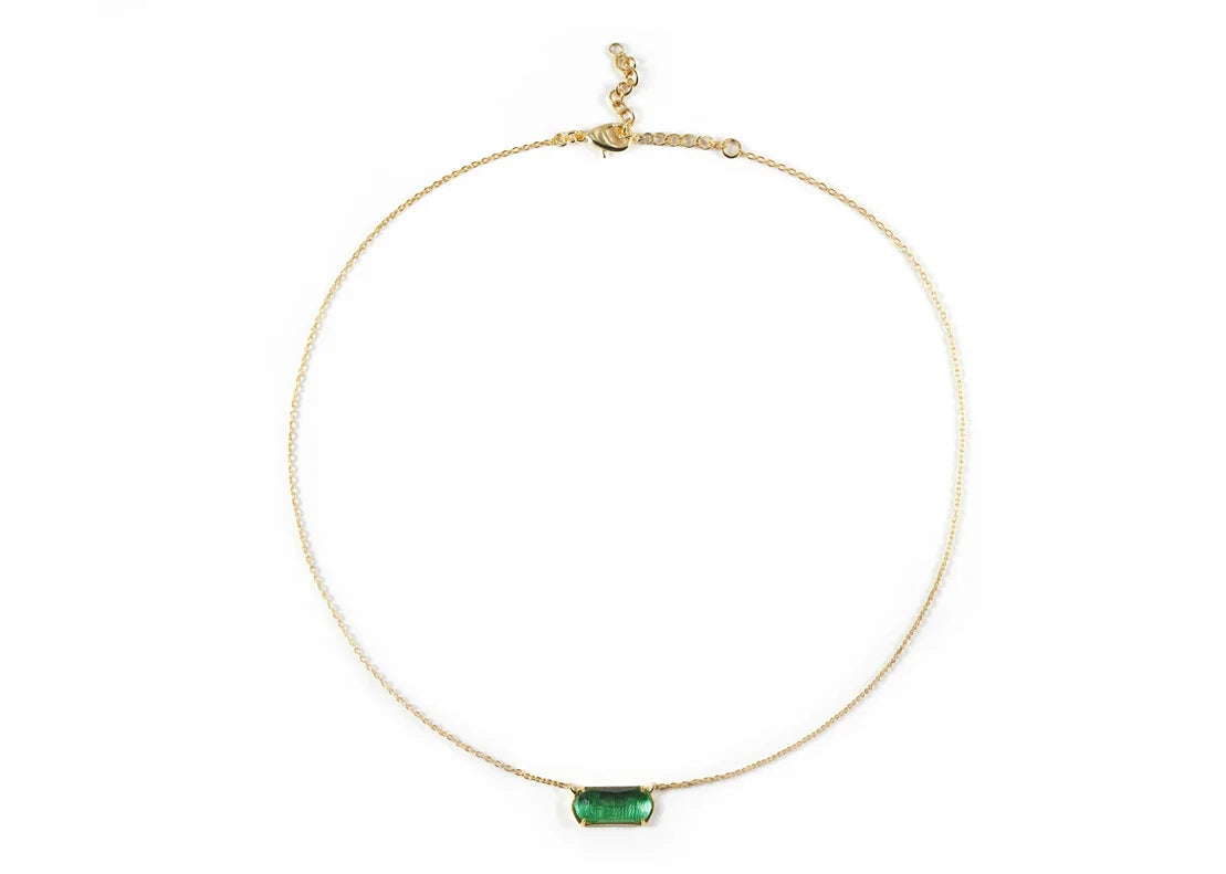 A chunky gold necklace with a green pendant.