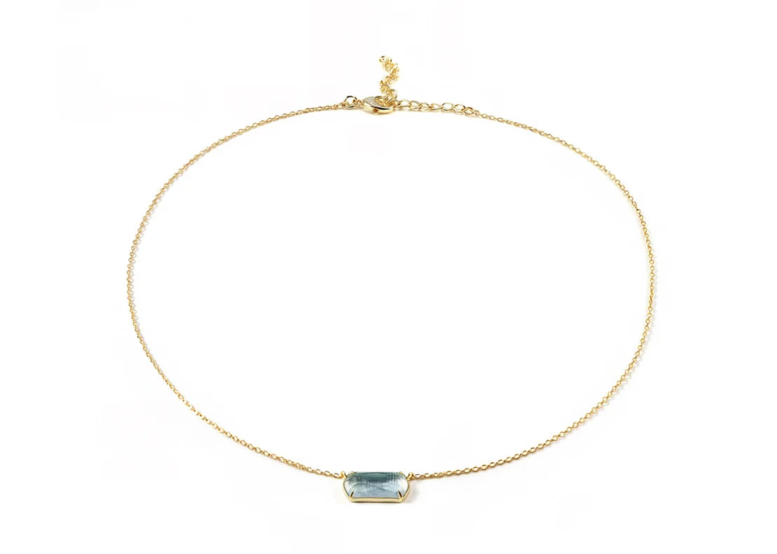 A gold necklace featuring blue stone necklace.