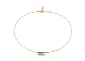 A gold necklace featuring blue stone necklace.