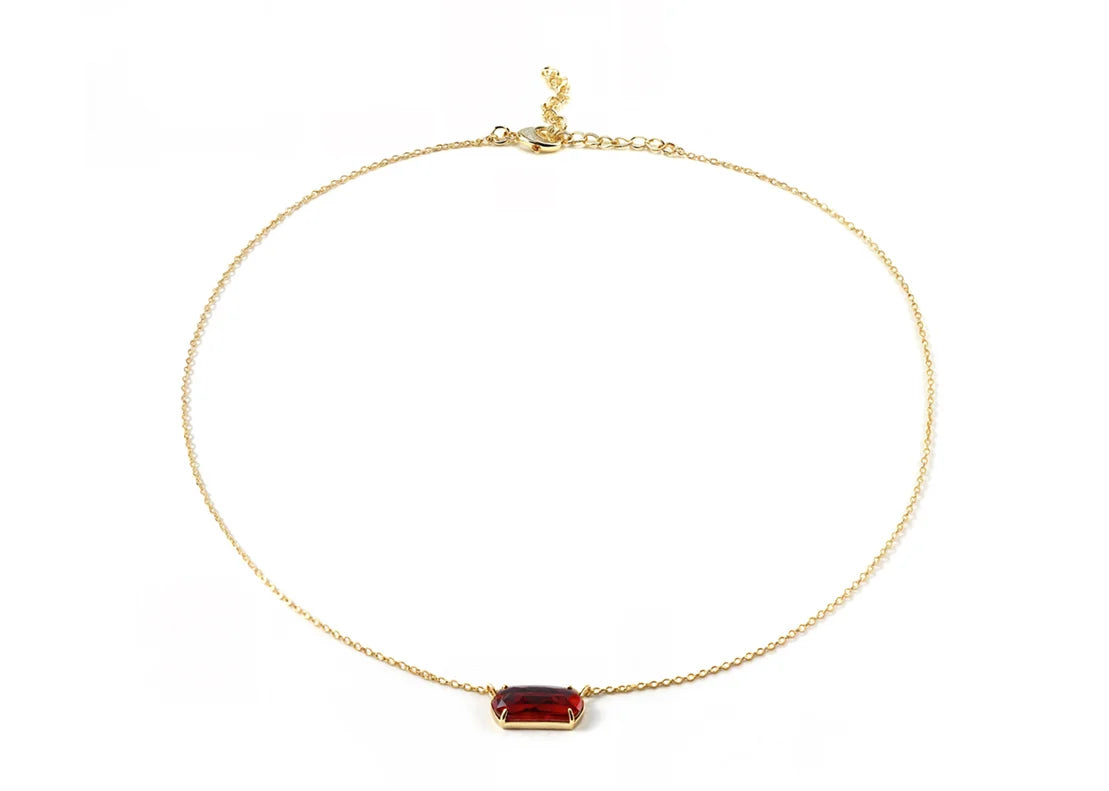 Close-up of a gold necklace with red pendant.