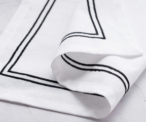 White dinner napkin featuring a chic trim border