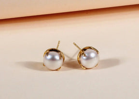 Beautiful pearl stud earrings with yellow gold-plated brass and a timeless design.