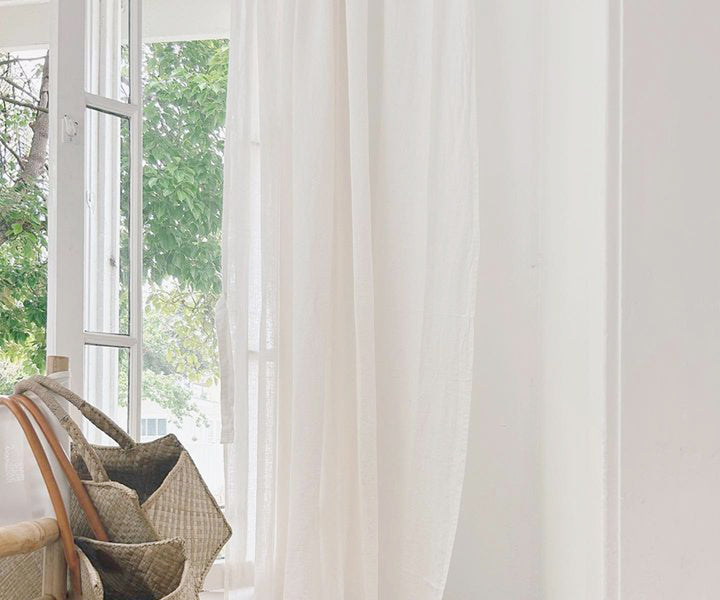 White Plain curtains in a neutral color hanging on a window, providing a simple and elegant look.