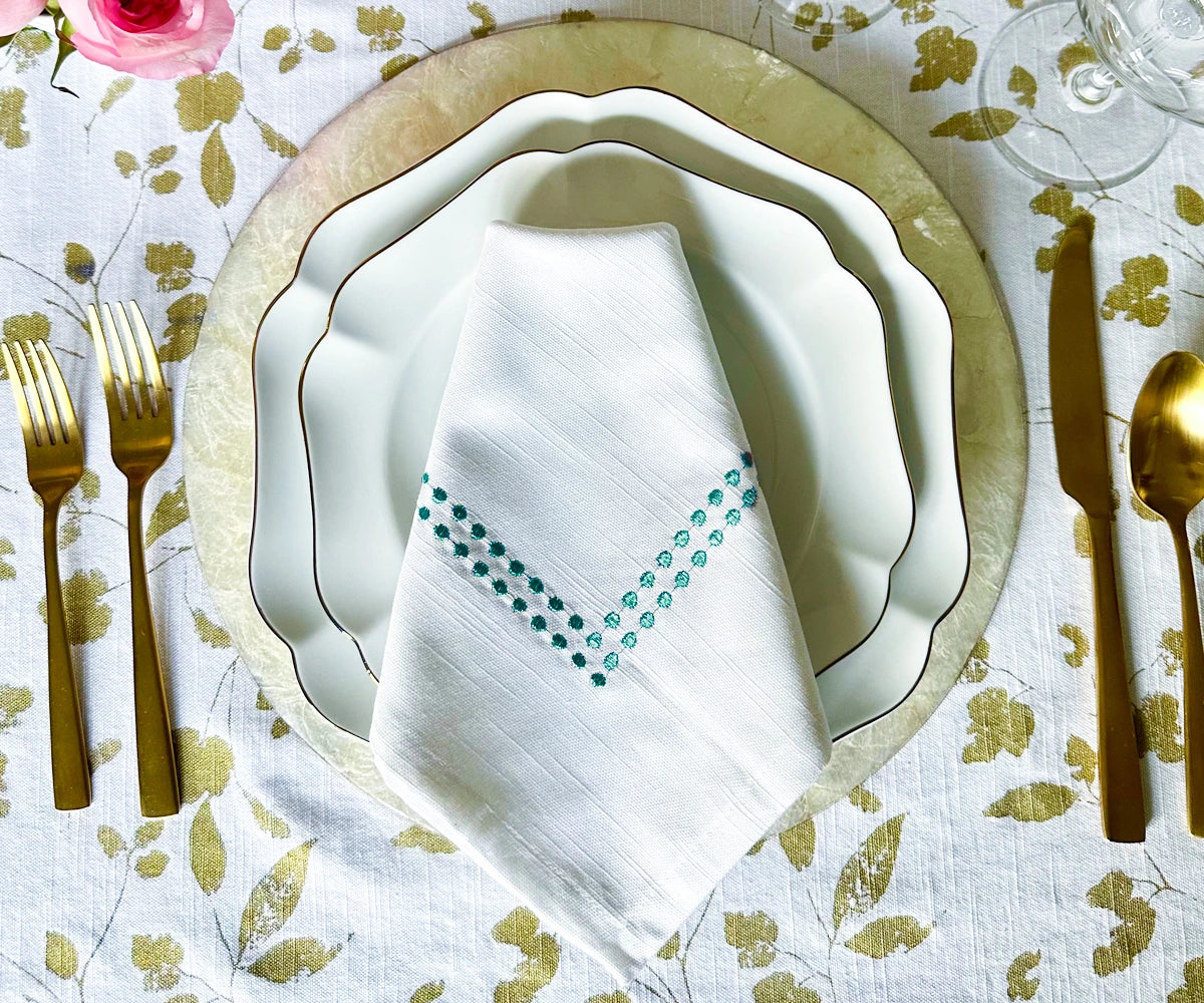 Red linen dinner napkins featuring a white embroidery pattern