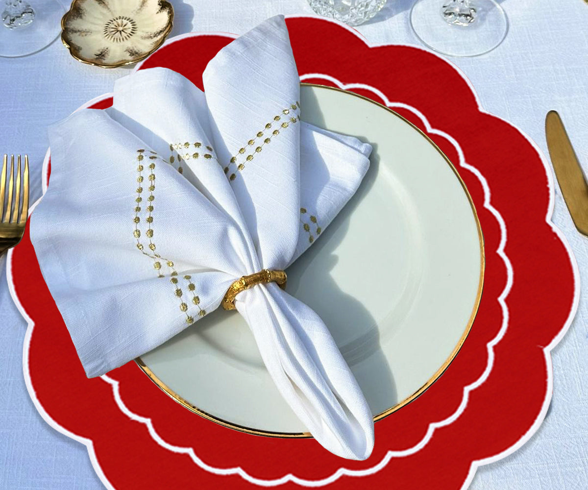 Round red placemats with a scallop pattern, providing a touch of sophistication and elegance to the table décor.