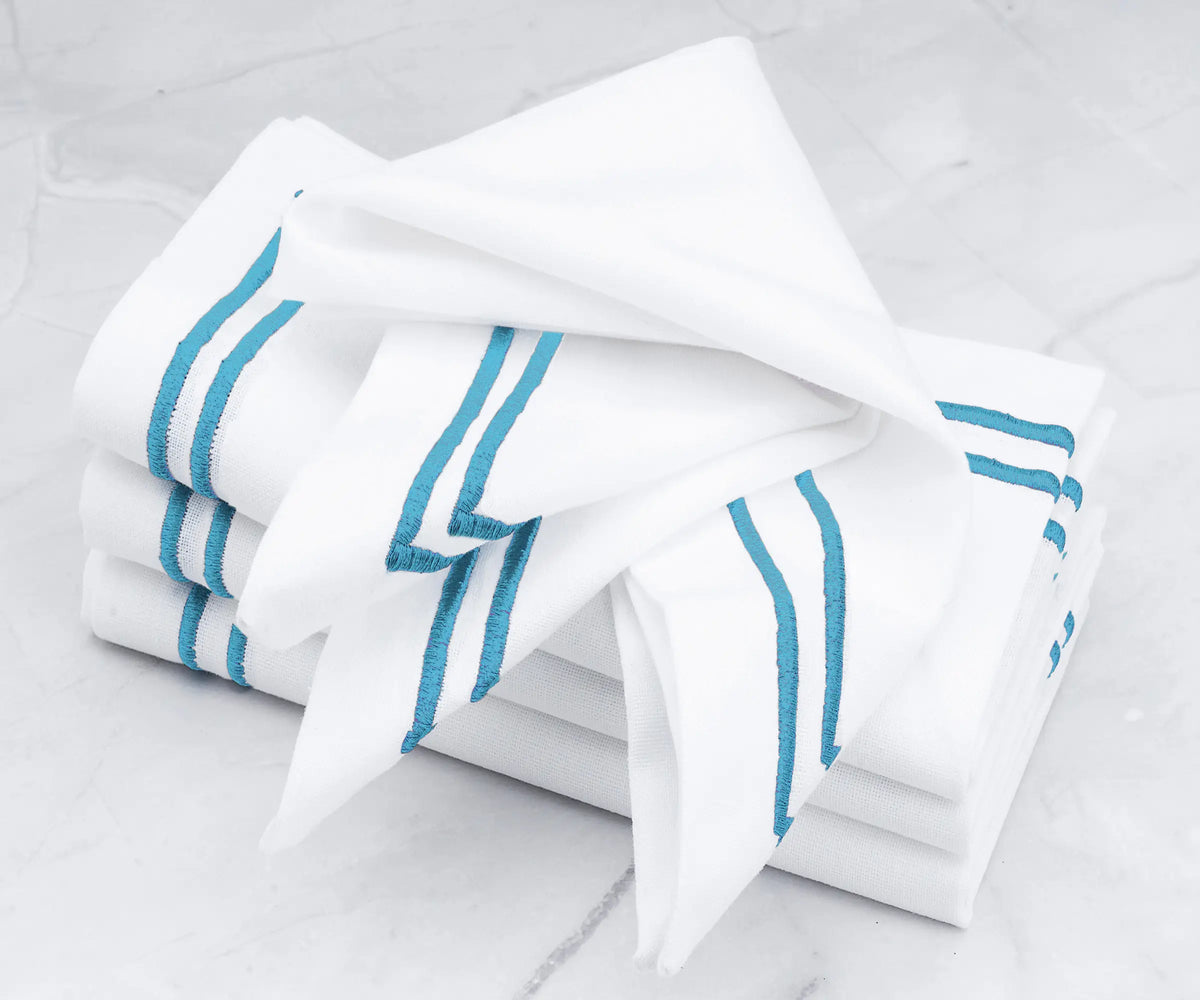 High-quality linen napkins featuring a double line of light blue embroidery.