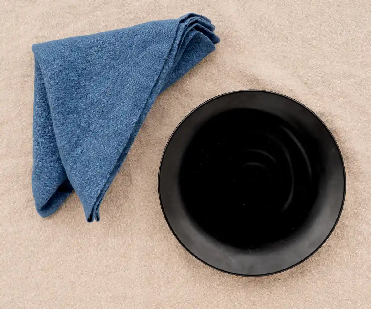 Vintage blue linen dinner napkin folded neatly for a classic table setting.