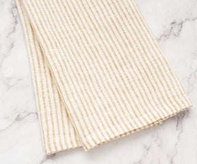 Breathable and absorbent linen towel in natural tones draped beside a sink