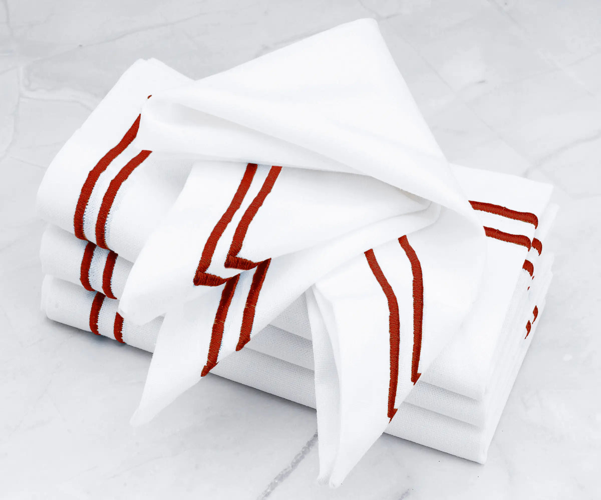 Luxurious linen napkins showcasing a double line of magenta embroidery.