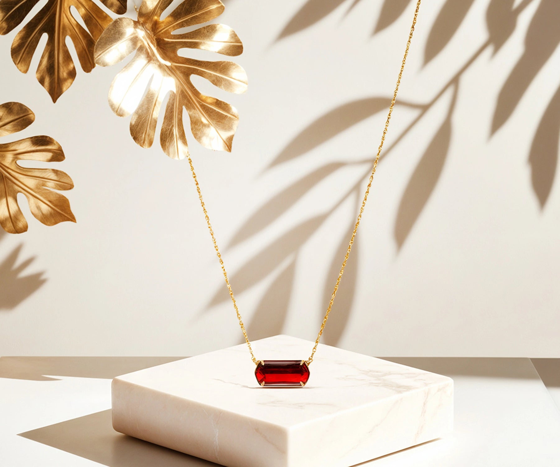 Stylish gold necklace with red pendant.