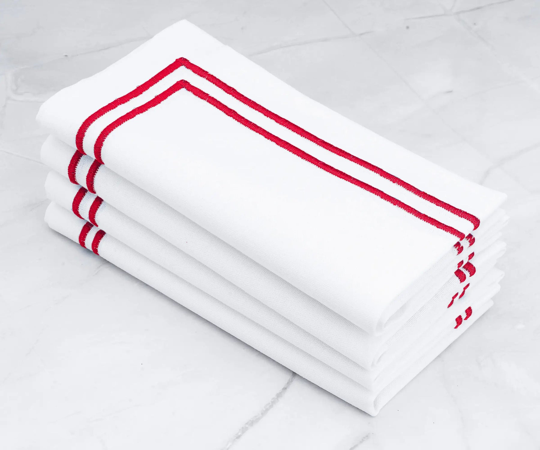 Crisp white napkins with a bold double line of red embroidery.