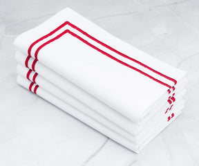 Crisp white napkins with a bold double line of red embroidery.