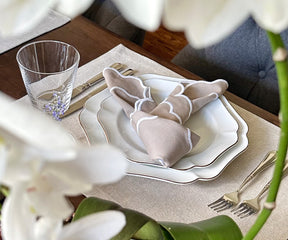 Elegant beige scallop napkins neatly folded on a rustic wooden table.