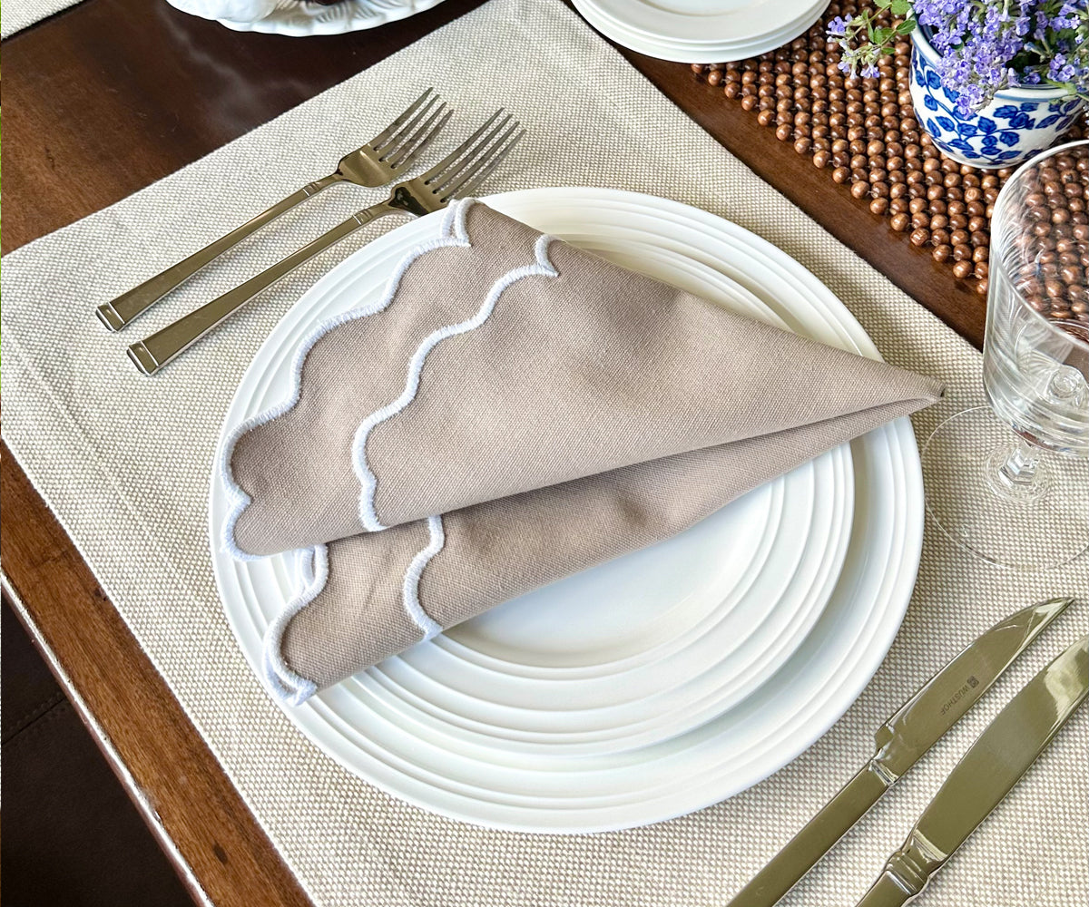 Beige scallop napkins with a subtle texture displayed in a modern dining room