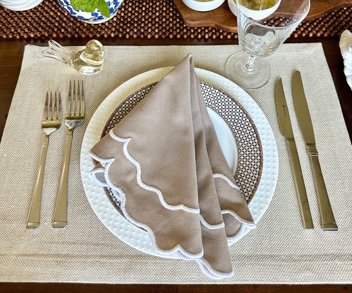 Chic beige scallop napkins adorning a table with candles and crystal glassware