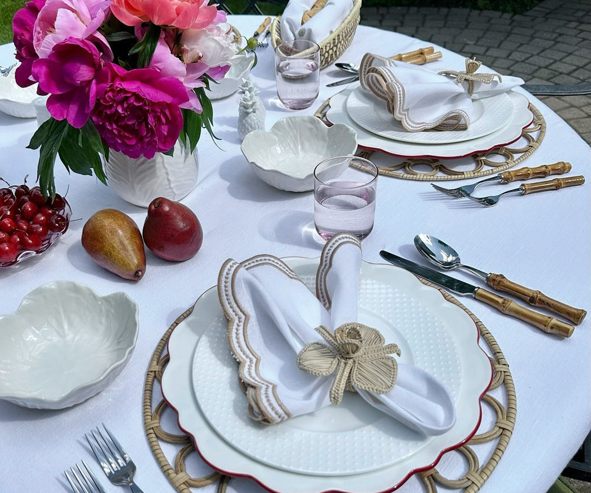 Beige scallop napkins arranged in a fan shape, showcasing intricate scalloped edges for a decorative effect.
