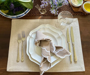 Artfully folded beige scallop napkins set for a high tea gathering.