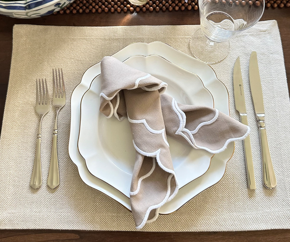 Beige scallop napkins in a buffet setting with matching table accessories