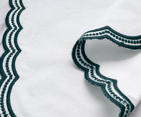 Chic linen napkin set with green embroidered scalloped borders, ideal for restaurants and events.