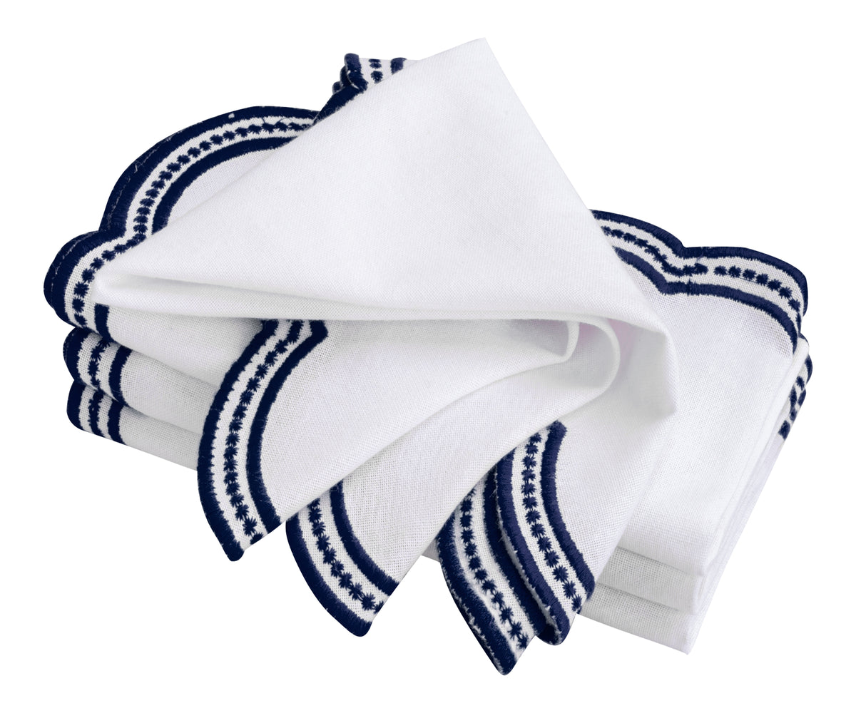 White and navy blue embroidered napkins with a classic scalloped design, ideal for home and restaurant use.