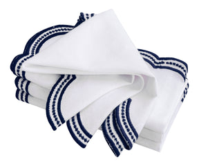 White and navy blue embroidered napkins with a classic scalloped design, ideal for home and restaurant use.