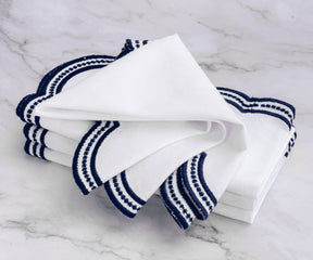 Sophisticated navy blue embroidered napkins with scalloped edges, perfect for fine dining and events.