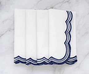 Stylish white napkins with delicate navy blue scalloped trim, adding a refined touch to any table.