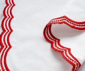 Elegant white napkins with red scalloped embroidery, perfect for festive and fine dining.