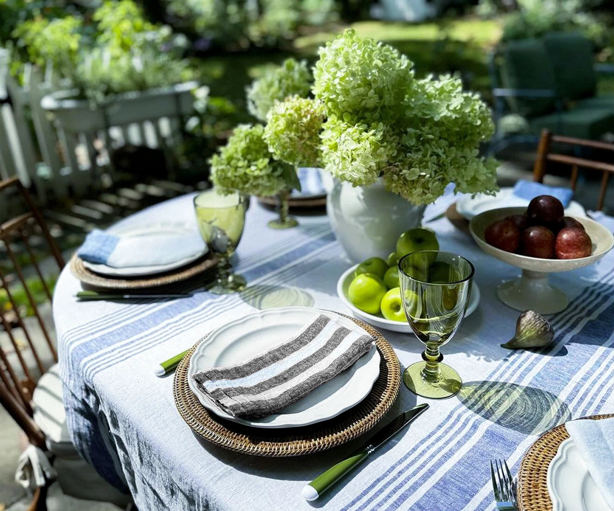 A stack of folded black and white linen napkins in muted pastel shades, resting on a kitchen counter, emphasizing their natural texture and softness.