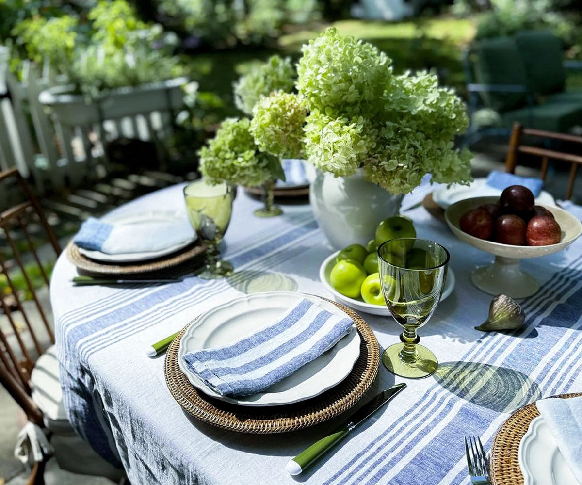 Blue and white linen napkins folded into fine cutlery on a formal dining table setting.