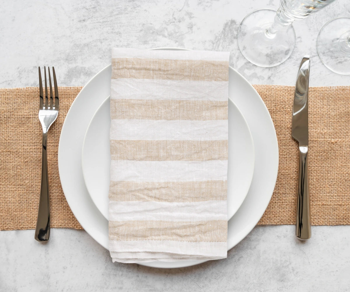 Thanksgiving linen napkins with a natural, textured weave, folded and stacked in a clean, minimalist arrangement.