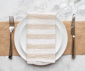 Thanksgiving linen napkins with a natural, textured weave, folded and stacked in a clean, minimalist arrangement.