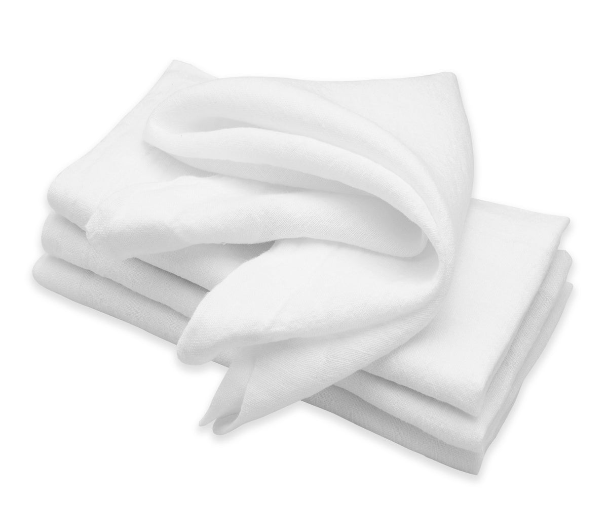 Stack of white linen napkins presented on a white tabletop