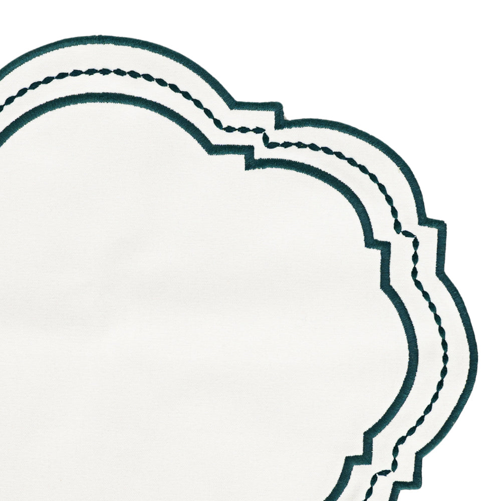 Oval placemat with a dotted pattern styled under sleek tableware.