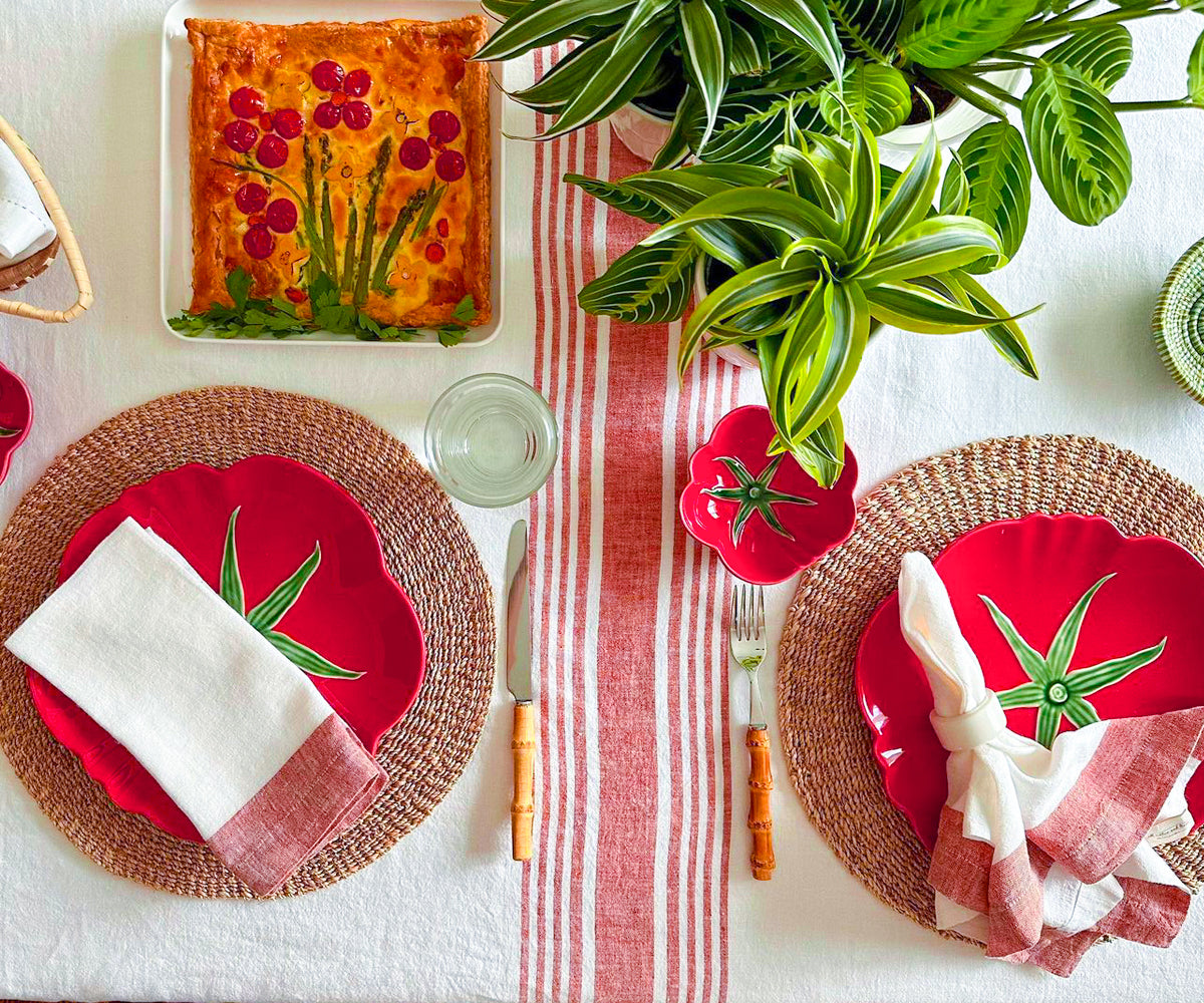 Dining table adorned with a white linen tablecloth and red and white dinnerware