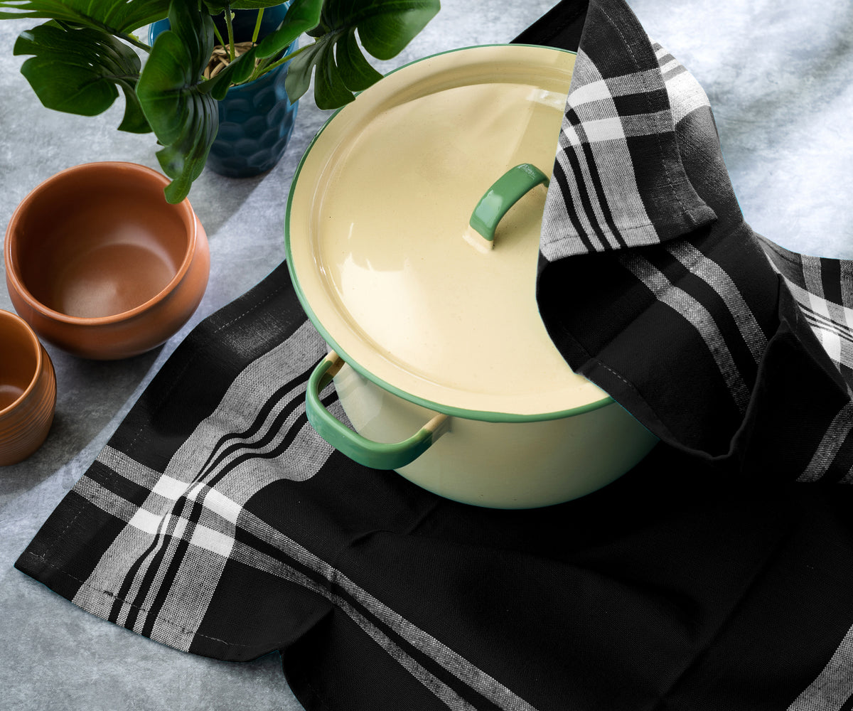 Farmhouse kitchen scene with a towel, cooking pot, and green plant on a wooden table